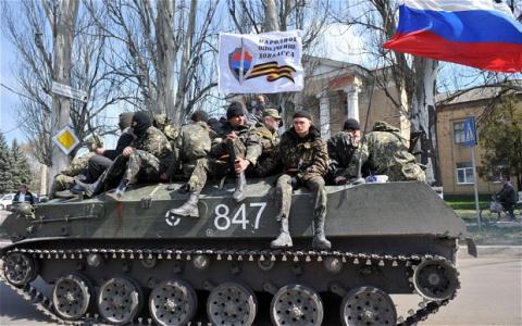 Những tay súng giấu mặt tại Donetsk trên một chiếc xe thiết giáp được cho là chiếm được của quân đội Ukraine