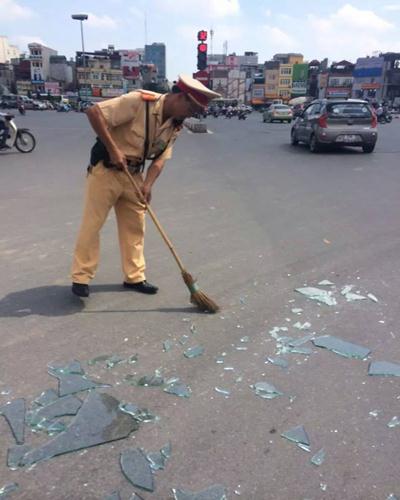Cảnh sát quét dọn những mảnh kính vỡ nằm rải rác trên đường.
