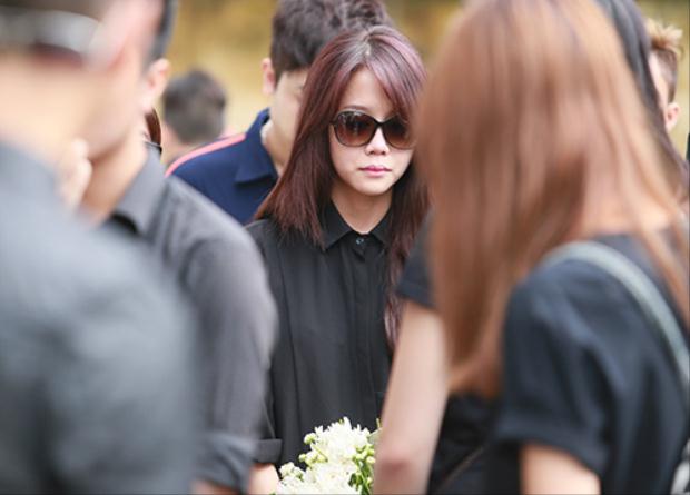 Cô mặc một cây đen và cầm trên tay bó cúc trắng đến viếng Toàn Shinoda  