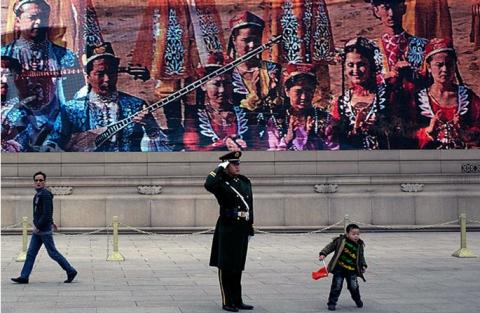 Cảnh sát Trung Quốc trước bức tranh về người Duy Ngô Nhĩ. Ảnh: Andy Wong/AP   