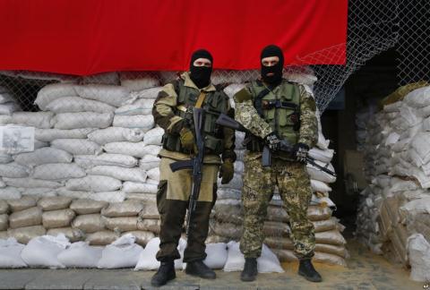 Những chiến binh ly khai được vũ trang chuyên nghiệp đứng gác tại một chốt chặn trong một thành phố ở miền đông