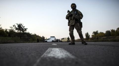 Một binh sĩ Ukraine tuần tra trên con đường gần thành phố Donetsk