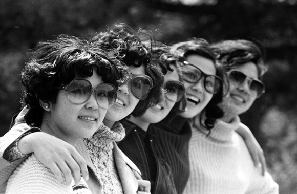 Các cô gái trẻ đeo kính râm đứng chụp ảnh tại một công viên ở Bắc Kinh năm 1980. 