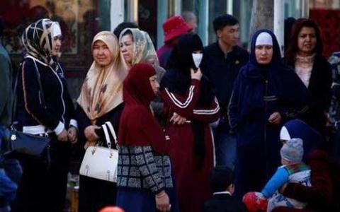 Phụ nữ người Duy Ngô Nhĩ đứng chờ xe bus ở Urumqi, thủ phủ Tân Cương, Trung Quốc 